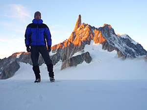 James standing in front of a sunlit mountain face